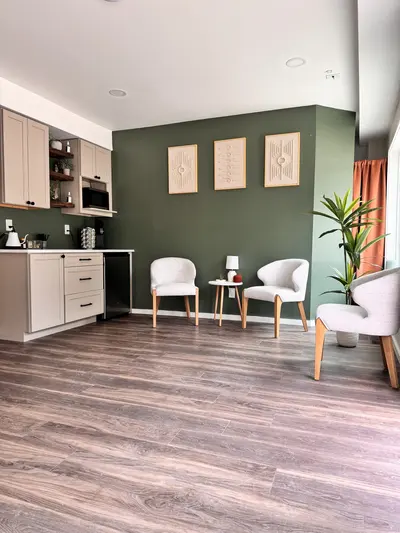 Lounge chairs beside a green accent wall at D2H Wellness