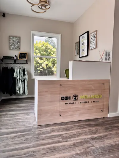 Wooden reception desk and D2H Wellness sign at the studio entrance